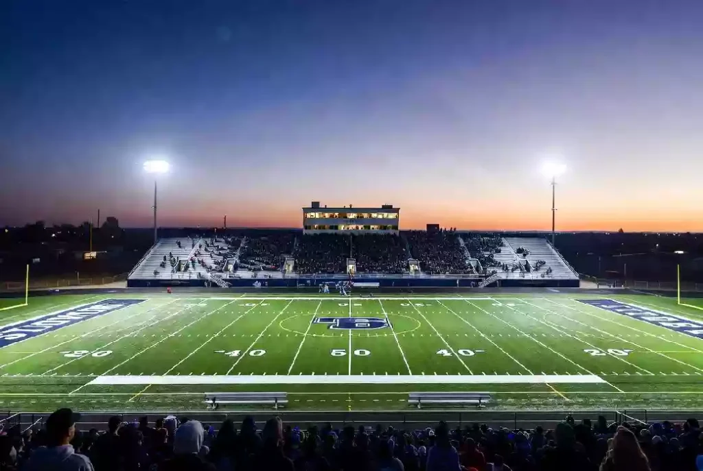 Wide view of a high school football stadium at dusk under stadium lights in Shawnee Oklahoma
