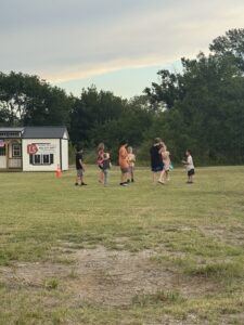 Children playing on the grassy field during the Wetumka Oklahoma community 4th of July block party