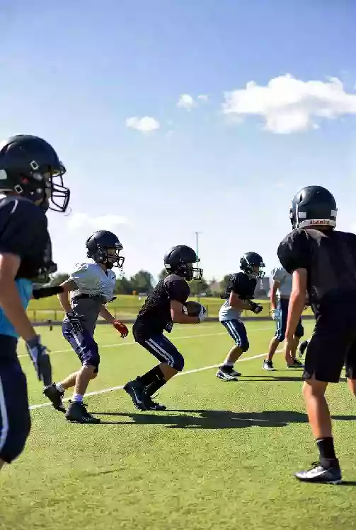 Vertical photo of high school football players practicing on the field in Holdenville Oklahoma