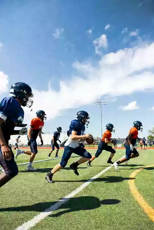 Vertical photo of high school football players practicing on the field in Norman Oklahoma