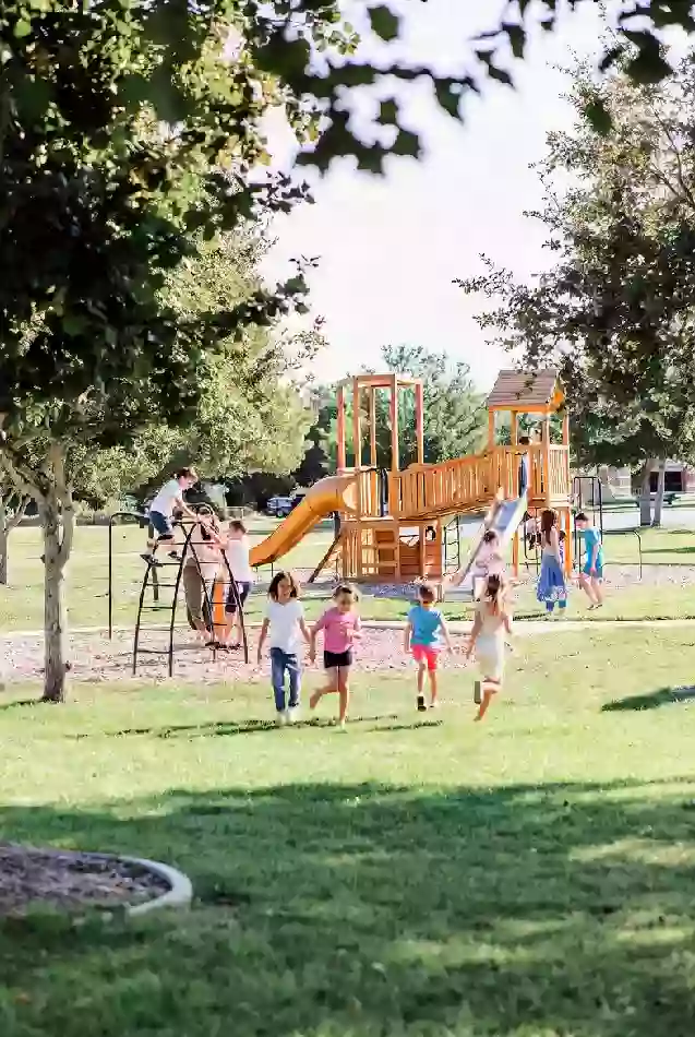 Children and families using a playground in a Broken Arrow park