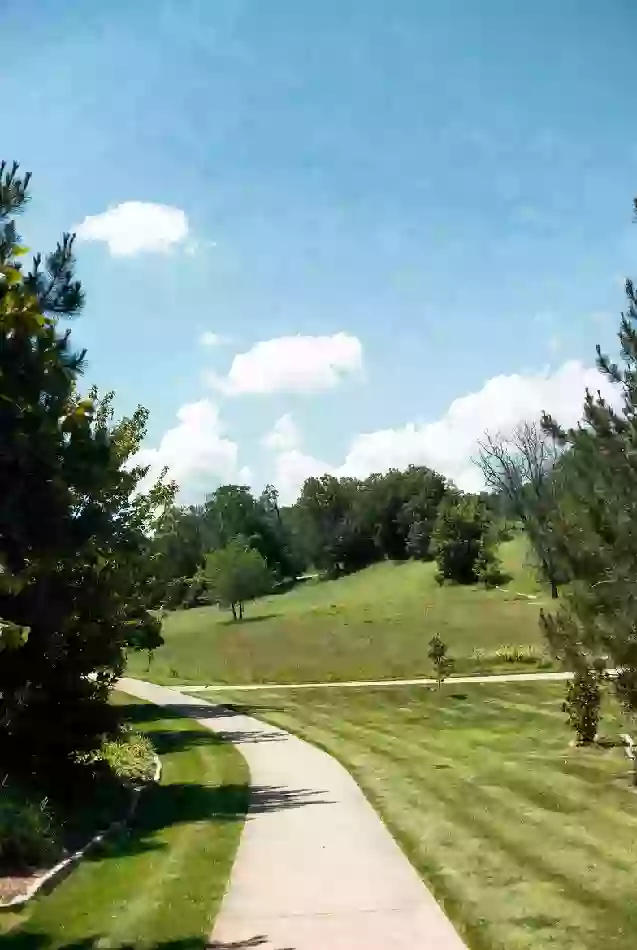 Clean walking path and open green space in a Broken Arrow park
