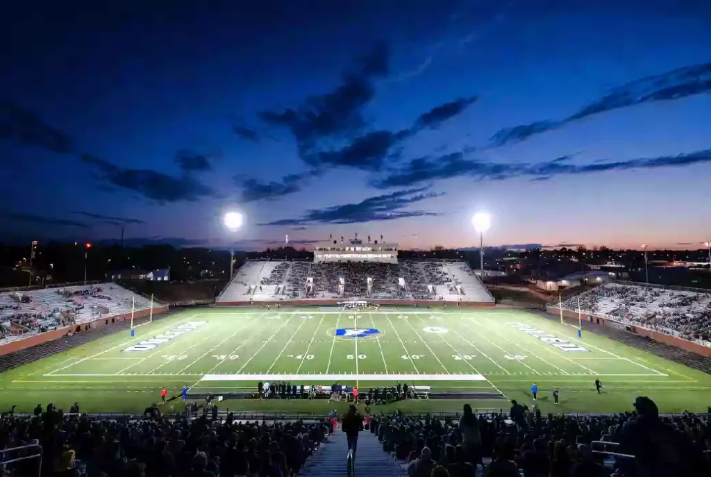 Wide view of a high school football stadium at dusk under stadium lights in Broken Arrow Oklahoma