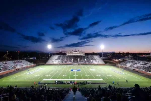 Wide view of a high school football stadium at dusk under stadium lights in Broken Arrow Oklahoma