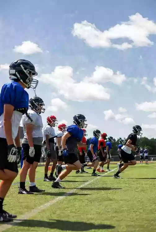 Vertical photo of high school football players practicing on the field in Broken Arrow Oklahoma