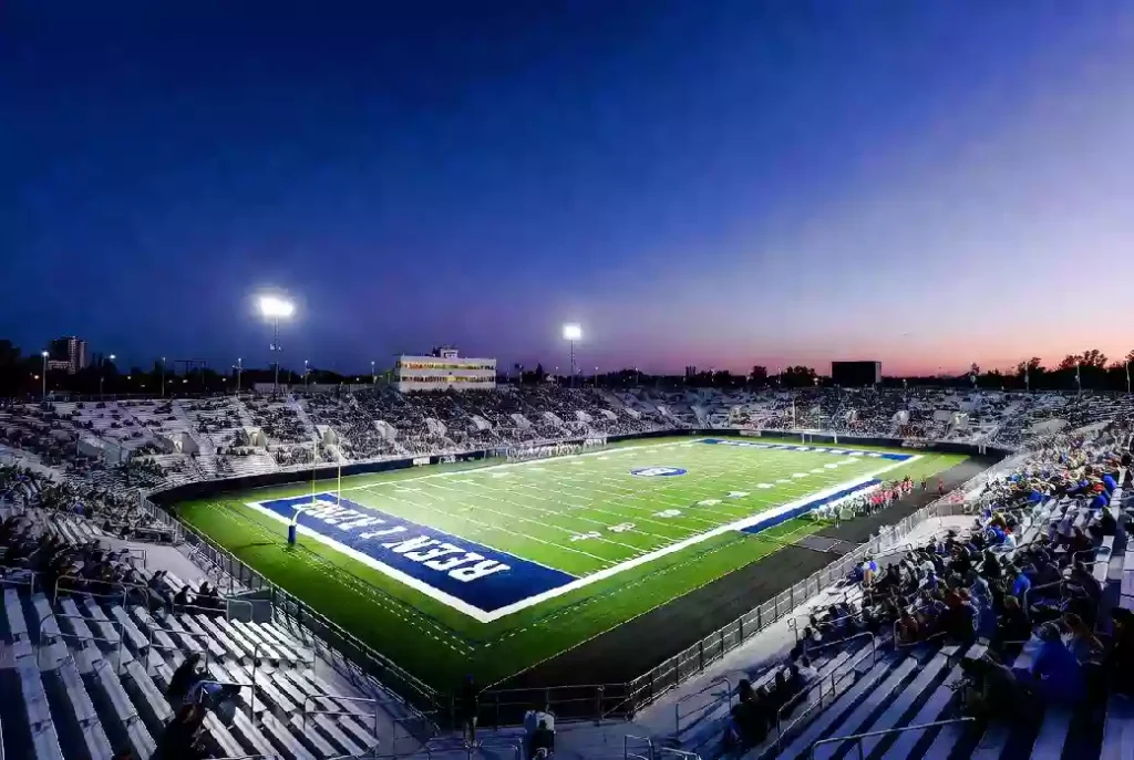 Wide view of a high school football stadium at dusk under stadium lights in Sapulpa Oklahoma