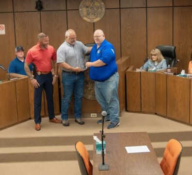 Lt. Matthew Duke center receiving plaque is honored by colleagues and city officials