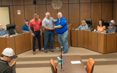 Lt. Matthew Duke center receiving plaque is honored by colleagues and city officials