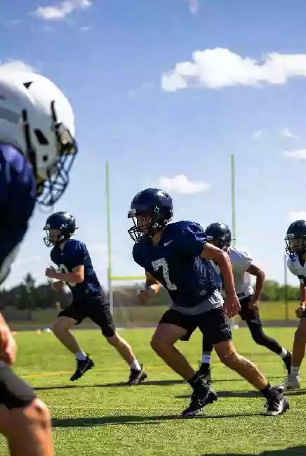 Vertical photo of high school football players practicing on the field in Okmulgee Oklahoma