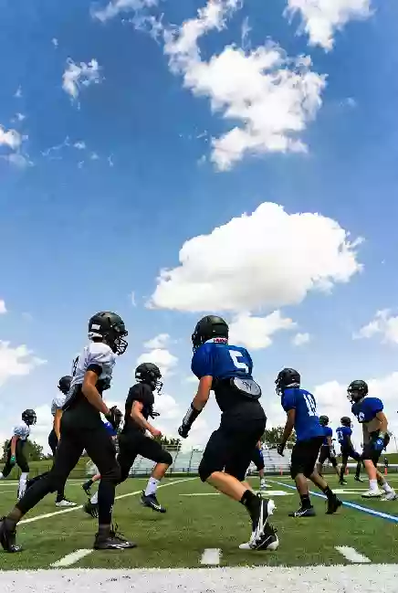 Vertical photo of high school football players practicing on the field in Mustang Oklahoma
