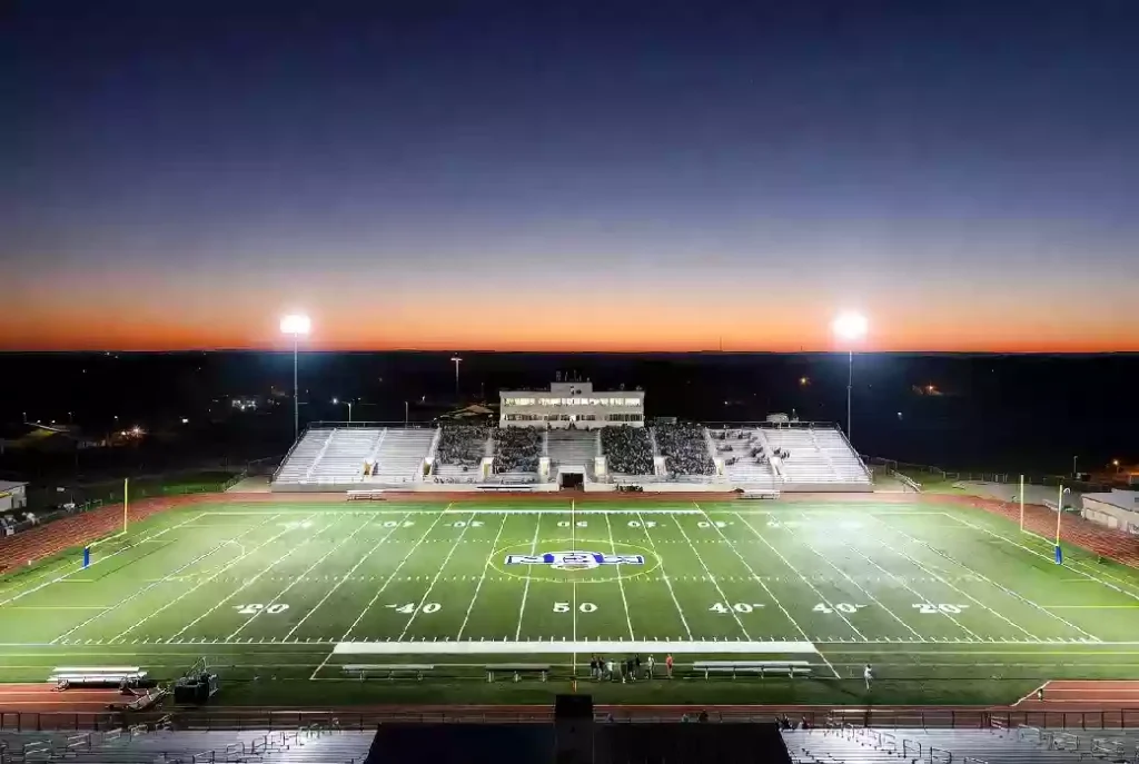 Wide view of a high school football stadium at dusk under stadium lights in Bixby Oklahoma