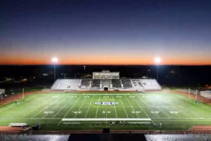 Wide view of a high school football stadium at dusk under stadium lights in Bixby Oklahoma