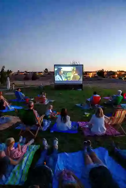 Families gathered on blankets for a free outdoor movie screening in an Owasso park