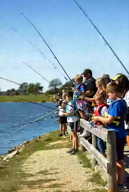 Children and families participating in a free fishing event at Claremore Lake