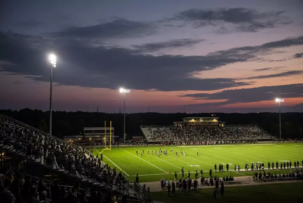 Wide view of a high school football stadium at dusk under stadium lights in Claremore Oklahoma