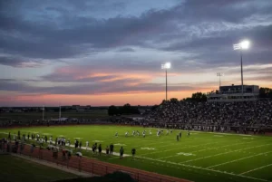 Wide view of a high school football stadium at dusk under stadium lights in El Reno Oklahoma