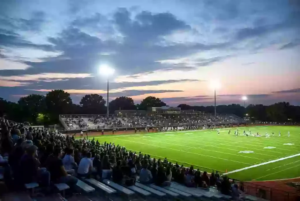 Wide view of a high school football stadium at dusk under stadium lights in Tahlequah Oklahoma