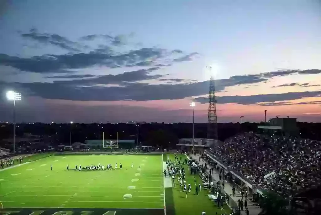 Wide view of a high school football stadium at dusk under stadium lights in Ardmore Oklahoma