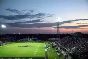 Wide view of a high school football stadium at dusk under stadium lights in Ardmore Oklahoma