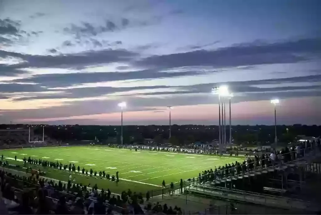 Wide view of a high school football stadium at dusk under stadium lights in Chickasha Oklahoma