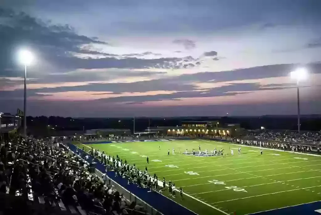 Wide view of a high school football stadium at dusk under stadium lights in Duncan Oklahoma