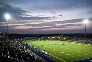 Wide view of a high school football stadium at dusk under stadium lights in Duncan Oklahoma
