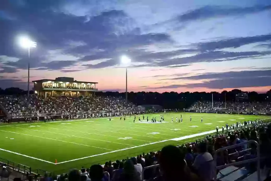 Wide view of a high school football stadium at dusk under stadium lights in Sand Springs Oklahoma