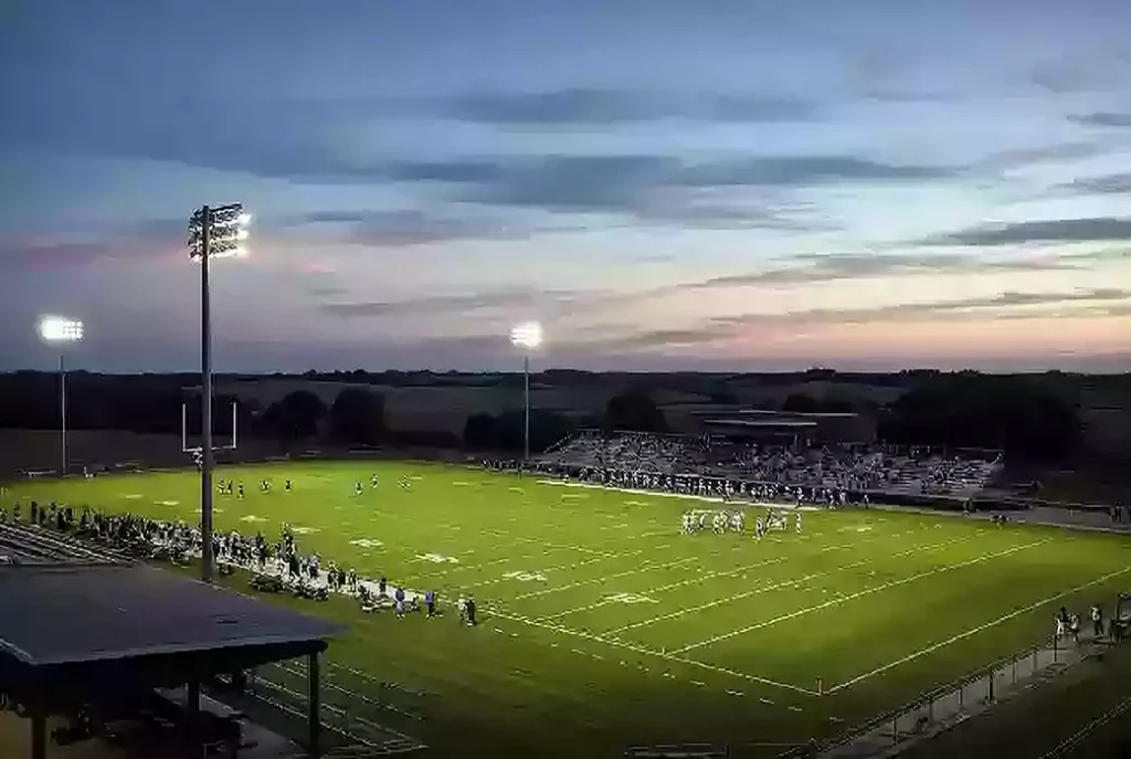 Wide view of a high school football stadium at dusk under stadium lights in Custer County Oklahoma