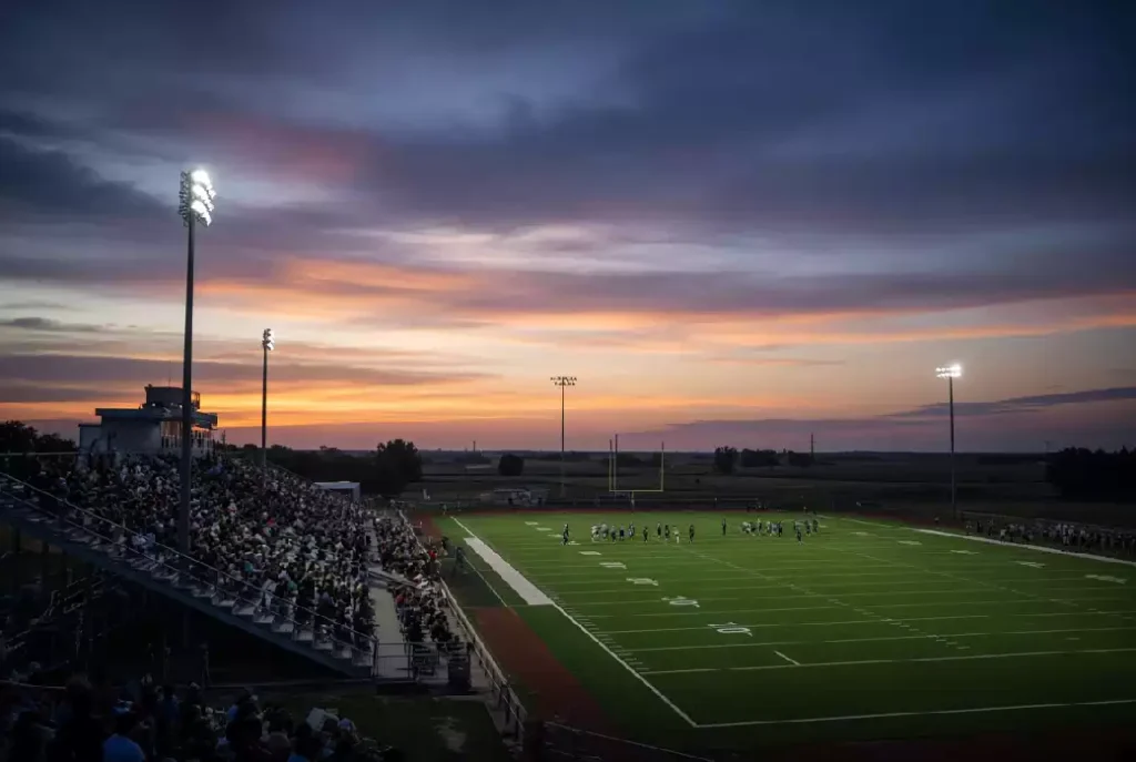 Wide view of a high school football stadium at dusk under stadium lights in Seminole County Oklahoma