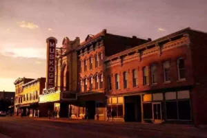 Wide view of historic downtown Muskogee with MUSKOGEE theatre marquee at golden hour