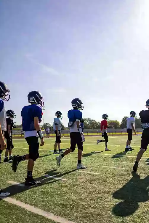 Vertical photo of high school football players practicing on the field in Edmond Oklahoma