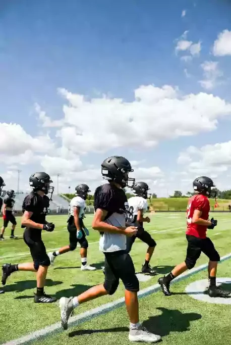 Vertical photo of high school football players practicing on the field in Oklahoma City