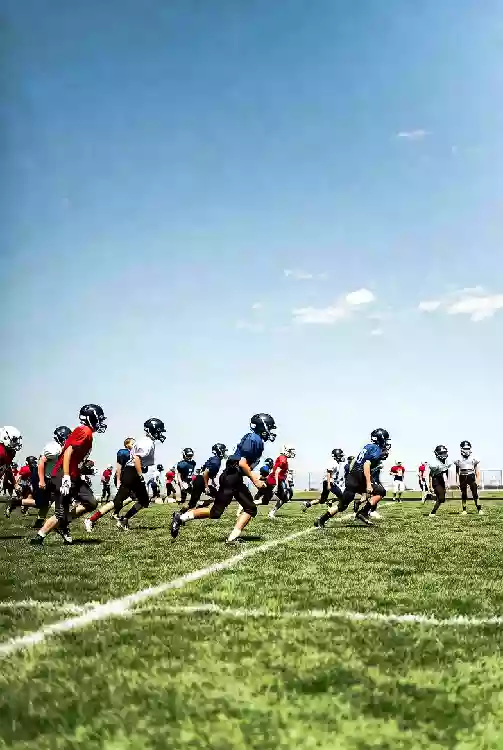 Vertical photo of high school football players practicing on the field in Yukon Oklahoma