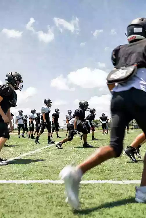 Vertical photo of high school football players practicing on the field in Tulsa Oklahoma
